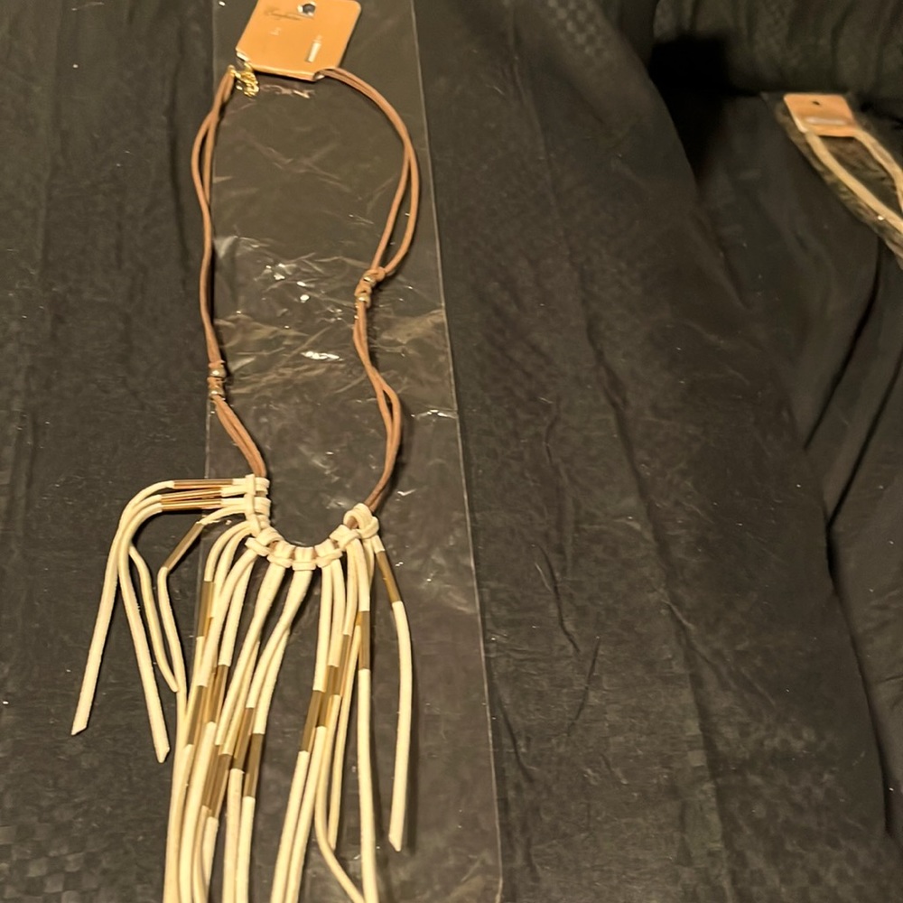 White faux leather necklace on dk dark brown leather cord with gold accents. Wow
